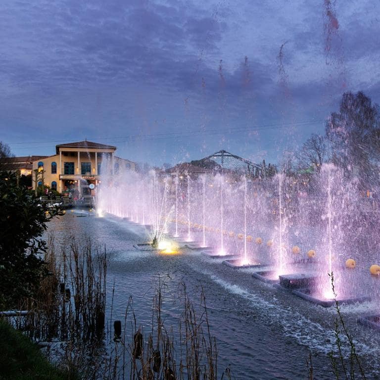Un cottage au crépuscule avec des jeux d'eau